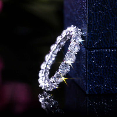 Luxury copper plated platinum ring adorned with sparkling oval and round zircons, reflecting light elegantly.