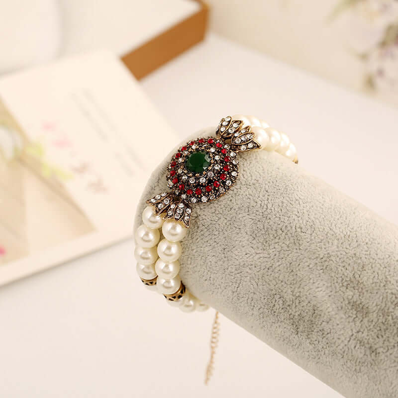 Luxury pearl bracelet with alloy clasp, featuring vibrant green and red stones, perfect for elegant occasions.