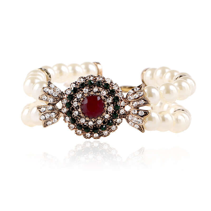 Elegant luxury pearl bracelet with alloy base and a striking ruby centerpiece, embellished with sparkling stones.
