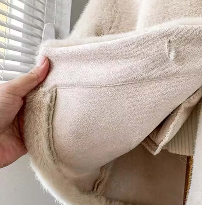 Close-up of the interior of a children's luxury light fur coat in apricot color, showcasing soft fabric and pocket details.