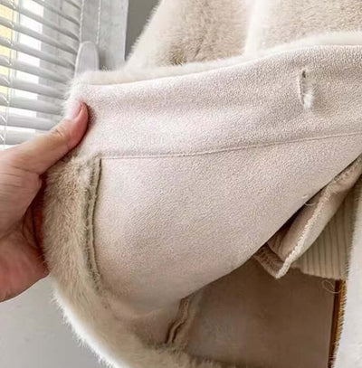 Close-up of the interior of a children's luxury light fur coat in apricot color, showcasing soft fabric and pocket details.